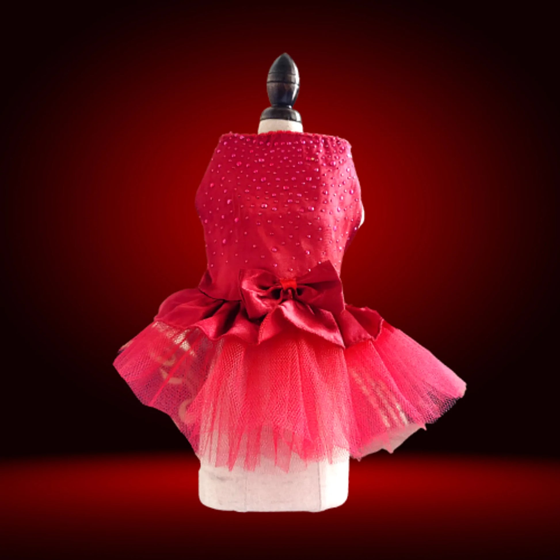 Red dress with a large bow on a mannequin against a red background