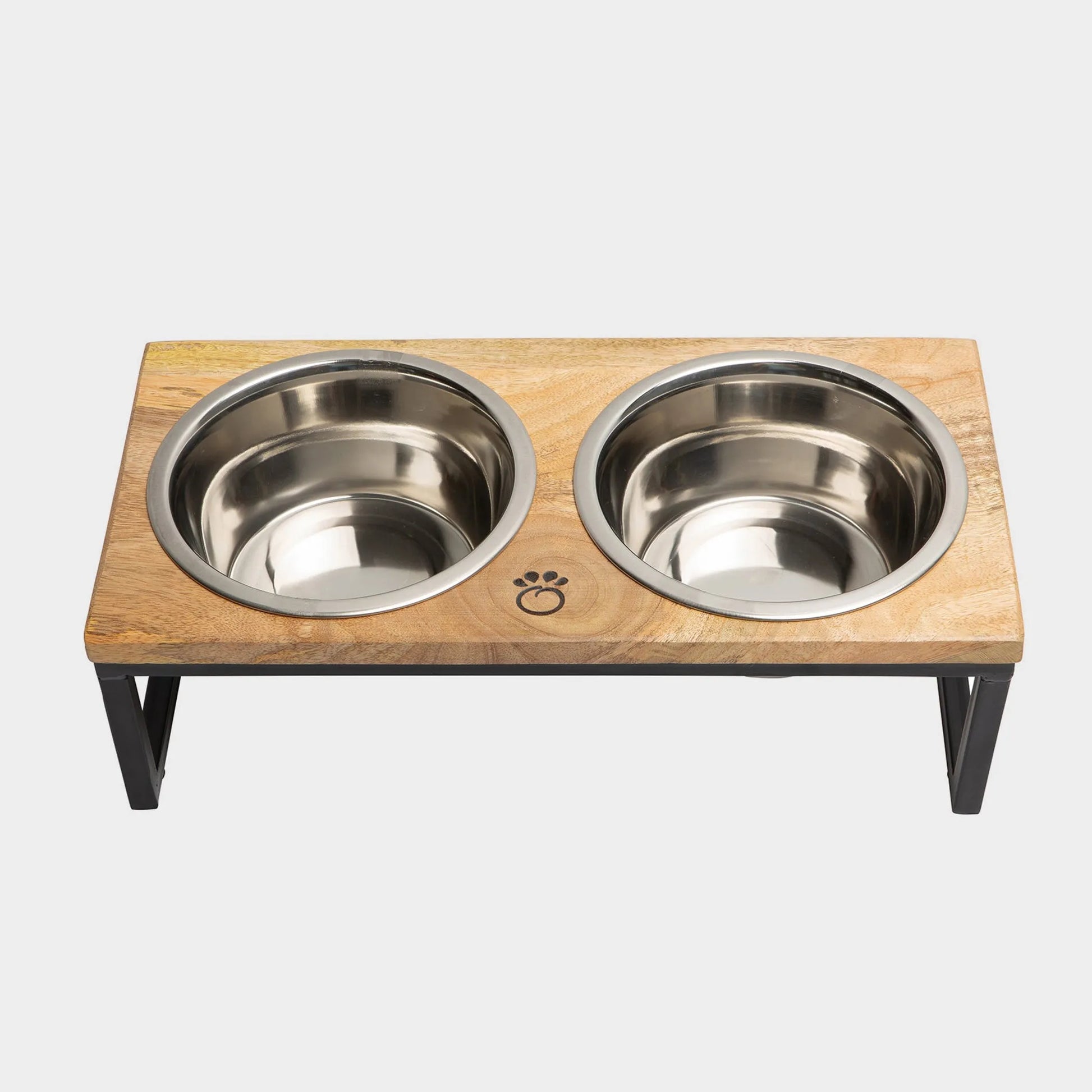 Wooden pet feeder with two stainless steel bowls on a light gray background