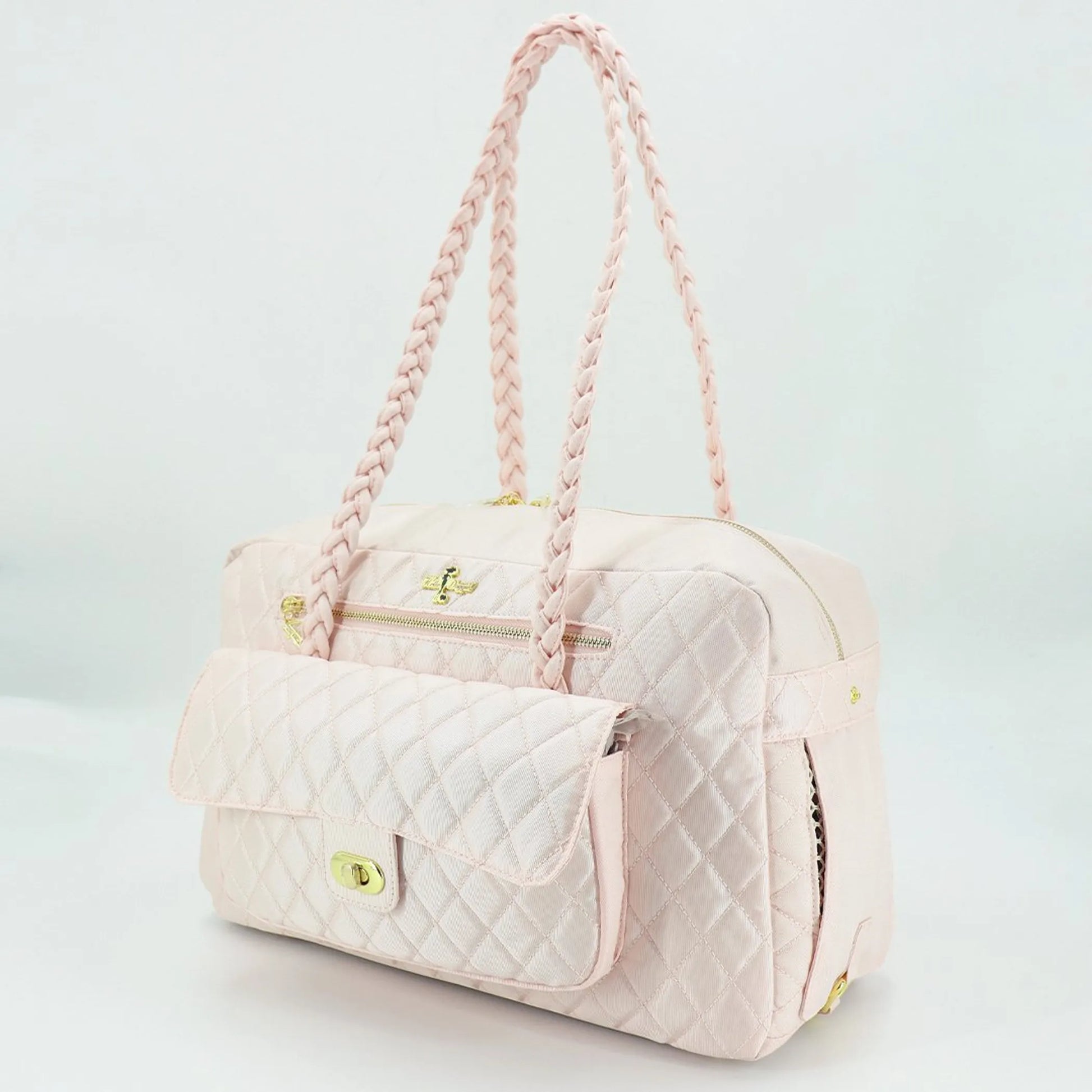 Quilted pet carrier with pink handle on a light gray background
