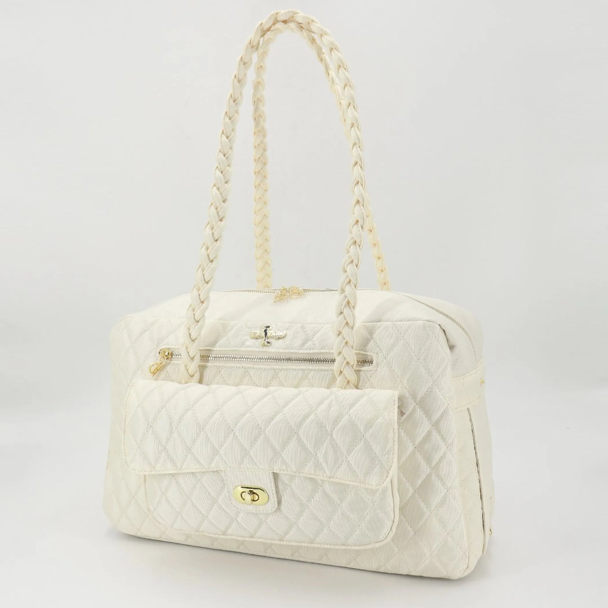 White quilted pet carrier with braided handle on a light gray background