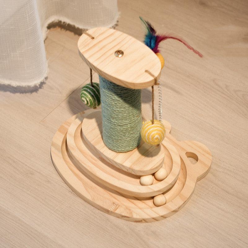 Wooden cat toy with yarn and feathers on a wooden floor