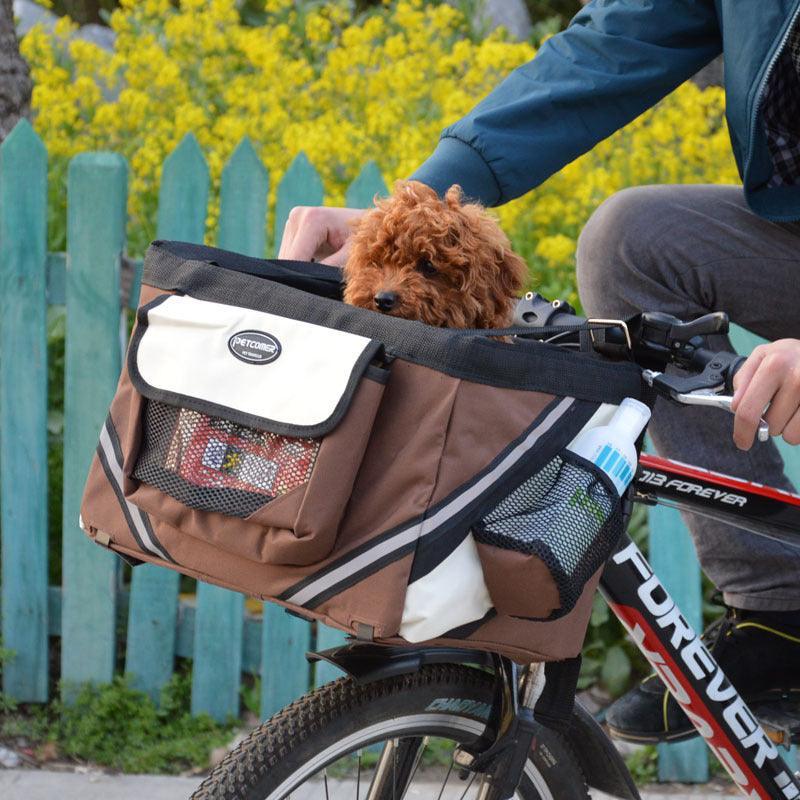 Brown pet carrier on a bicycle with a small dog inside, against a blurred natural background.